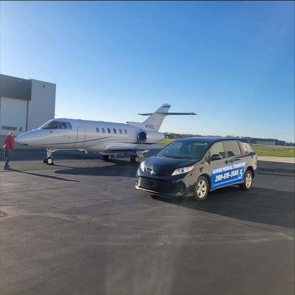 Minivan on airport runway next to private jet
